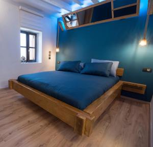 łóżko w pokoju z niebieską ścianą w obiekcie Casa de Mikel w mieście Rodos