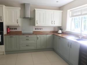 a kitchen with white cabinets and a sink at Haul y Bore in Aberystwyth