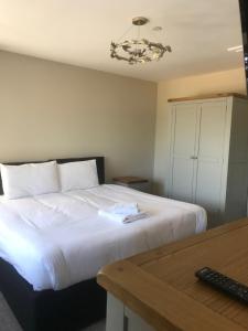 um quarto com uma grande cama branca e uma mesa em Haul y Bore em Aberystwyth