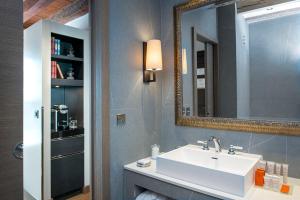 uma casa de banho com um lavatório e um espelho em Hôtel Les Armures em Genebra