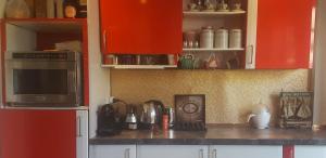 a kitchen with red cabinets and a counter top at Lovely double bedroom in Rotherhithe in London