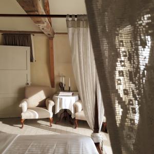 a bedroom with a table and two chairs and a window at Hotel Recour in Poperinge