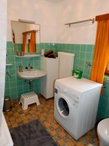 a bathroom with a washing machine and a sink at Haus Berauer in Fieberbrunn