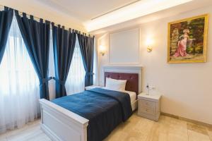 1 dormitorio con 1 cama y una pintura en la pared en Grand Hotel Palladium, en Múnich