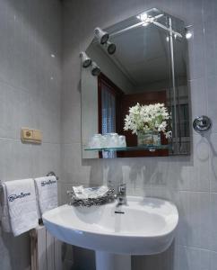 uma casa de banho com um lavatório branco e um espelho. em San Marcos Salnés em Cambados