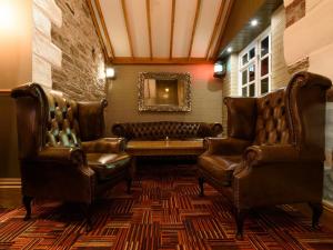 a waiting room with leather chairs and a couch at The Britannia Inn & Waves Restaurant in Par