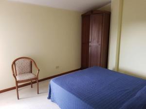 a bedroom with a bed and a chair and a cabinet at Oasi Club Village in Rocca dʼEvandro