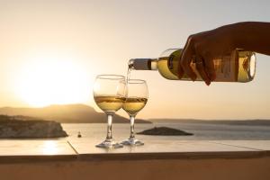 a person pouring wine into a wine glass at Manos Apartments in Almyrida