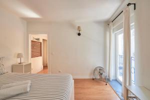 um quarto branco com uma cama e uma janela em MEET LISBOA | Your Home in Lisbon | City Centre em Lisboa