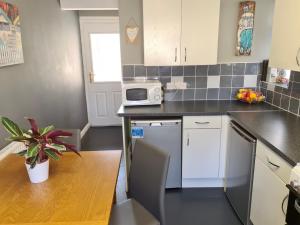 a small kitchen with a table and a microwave at love-lyph stays in Watford