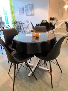 una mesa con sillas y una naranja encima. en Pronova Hotell & Vandrarhem, en Norrköping