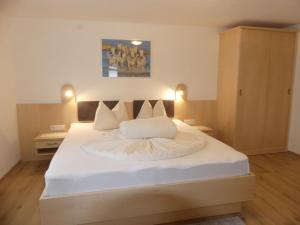 a bedroom with a large bed with white sheets at Holiday Home Wallner - FUC110 by Interhome in Fusch an der Glocknerstraße