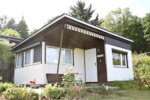 a small white house with a black roof at Talblick 2 - Ihr Zuhause : das Ferienhaus mitten im idyllischen Tal in Bad Bibra