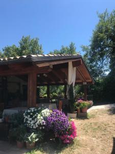 einen Holzpavillon mit Blumen im Hof in der Unterkunft Country House Antiche Dimore in Abbateggio