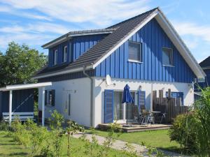 a blue and white house with a patio at Holiday Home Achterblick 2 by Interhome in Altefähr