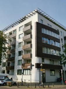 ベルリンにあるArt'Appart Suiten - kontaktloser Check-Inの高層アパートメントの建物で、正面に自転車が駐車しています。