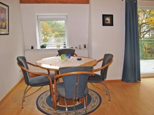 a dining room with a table and chairs at Apartment Haus Berlin-5 by Interhome in Loddin