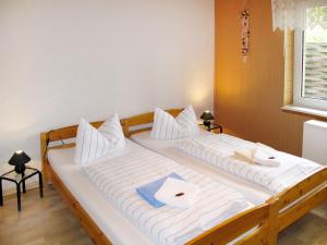 Cette chambre comprend 2 lits avec des draps et des oreillers blancs. dans l'établissement Apartment Old Hüsung by Interhome, à Mirow
