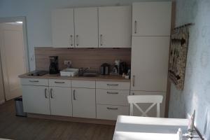 a kitchen with white cabinets and a sink at Ferienwohnung in Drentwede in Drentwede
