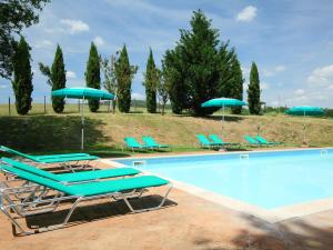 a swimming pool with lounge chairs and umbrellas at Holiday Home Podere S Giovanni by Interhome in Casole dʼElsa