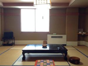 a room with a table and a large window at Resort Inn Chitose in Nozawa Onsen