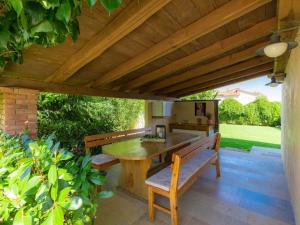 a patio with a wooden table and a bench at Holiday Home Hrelja - ROJ418 by Interhome in Žminj