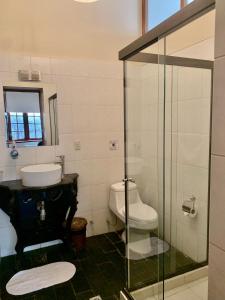 a bathroom with a toilet and a sink and a shower at Hotel Boutique El Consulado in La Paz