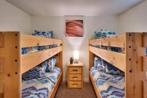 a bedroom with two bunk beds and a night stand at 5L Top Floor Redcliff Condo in Moab