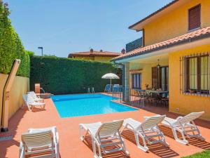 patio z krzesłami i basenem w obiekcie Villa Villa Giada by Interhome w mieście Villa Bensi