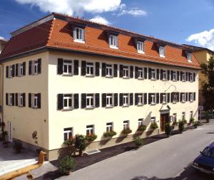 un grand bâtiment blanc avec un toit rouge dans l'établissement Aspire Kronprinz, Trademark Collection by Wyndham, à Schwäbisch Hall