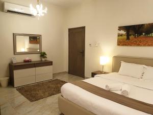 a bedroom with a large bed and a mirror at Muscat Royal Suites in Seeb