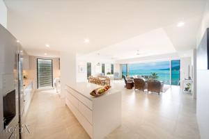a kitchen and living room with a view of the ocean at Splendeur Sur La Mer Premiere in Airlie Beach