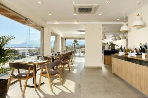 a restaurant with tables and chairs and a bar at Enorme Santanna Beach in Ierápetra