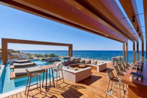 a house with a pool and a deck with chairs at Enorme Santanna Beach in Ierapetra