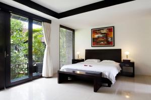 a bedroom with a bed and a large window at S'cape Condotel in Sanur +21 photos