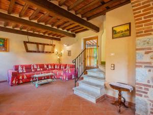 a living room with a red couch and stairs at Holiday Home I Pioppi - CMA107 by Interhome in Camaiore