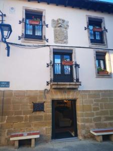 un edificio con ventanas, una puerta y dos bancos en Villa Carpe Diem en Zarratón