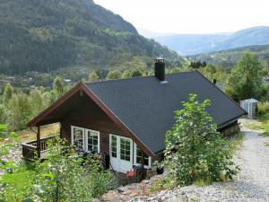 a small house with a mountain in the background at Holiday Home Peer Gynt by Interhome in Sogndal