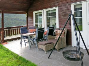 a patio with chairs and a table and a grill at Holiday Home Peer Gynt by Interhome in Sogndal