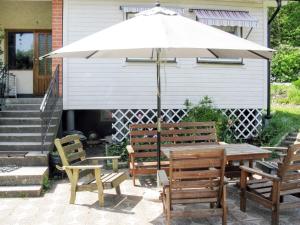 a table and chairs with an umbrella on a patio at Holiday Home Trollsjö Stegeborg - OST102 by Interhome in Norrkrog