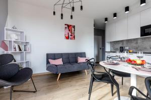 a kitchen and a living room with a table and chairs at Apartament Old Town Nest in Gdańsk