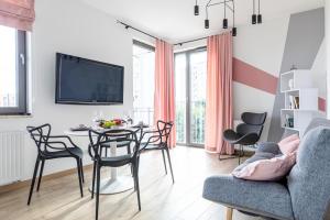 sala de estar con mesa, sillas y TV en Apartament Old Town Nest en Gdansk