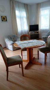 a living room with a table and chairs and a couch at Ferienwohnungen am Uferpark Blaser in Friedrichshafen