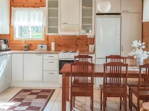 - une cuisine avec des placards blancs, une table et des chaises dans l'établissement Holiday Home Beige 2 by Interhome, à Kinnula