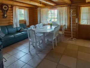 - une salle à manger avec une table, des chaises et un canapé dans l'établissement Holiday Home Harjurinne by Interhome, à Kinnula