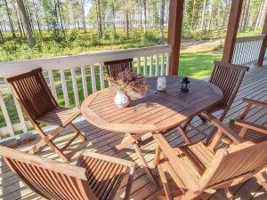 ein Holztisch und Stühle auf einer Holzterrasse in der Unterkunft Holiday Home Graniitti 3 by Interhome in Kinnula