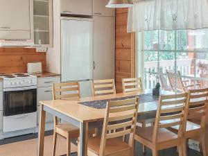 une cuisine avec une table et des chaises ainsi qu'une fenêtre dans l'établissement Holiday Home Graniitti 3 by Interhome, à Kinnula