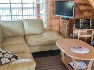 ein Wohnzimmer mit einem Sofa und einem TV in der Unterkunft Holiday Home Graniitti 3 by Interhome in Kinnula