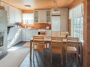 eine Küche mit Esstisch und Stühlen in der Unterkunft Holiday Home Graniitti 3 by Interhome in Kinnula