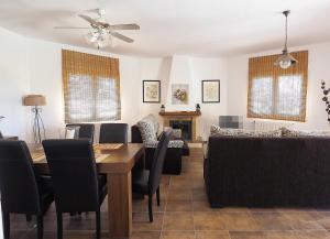 sala de estar con mesa, sillas y sofá en Casa Soleada en Arenas